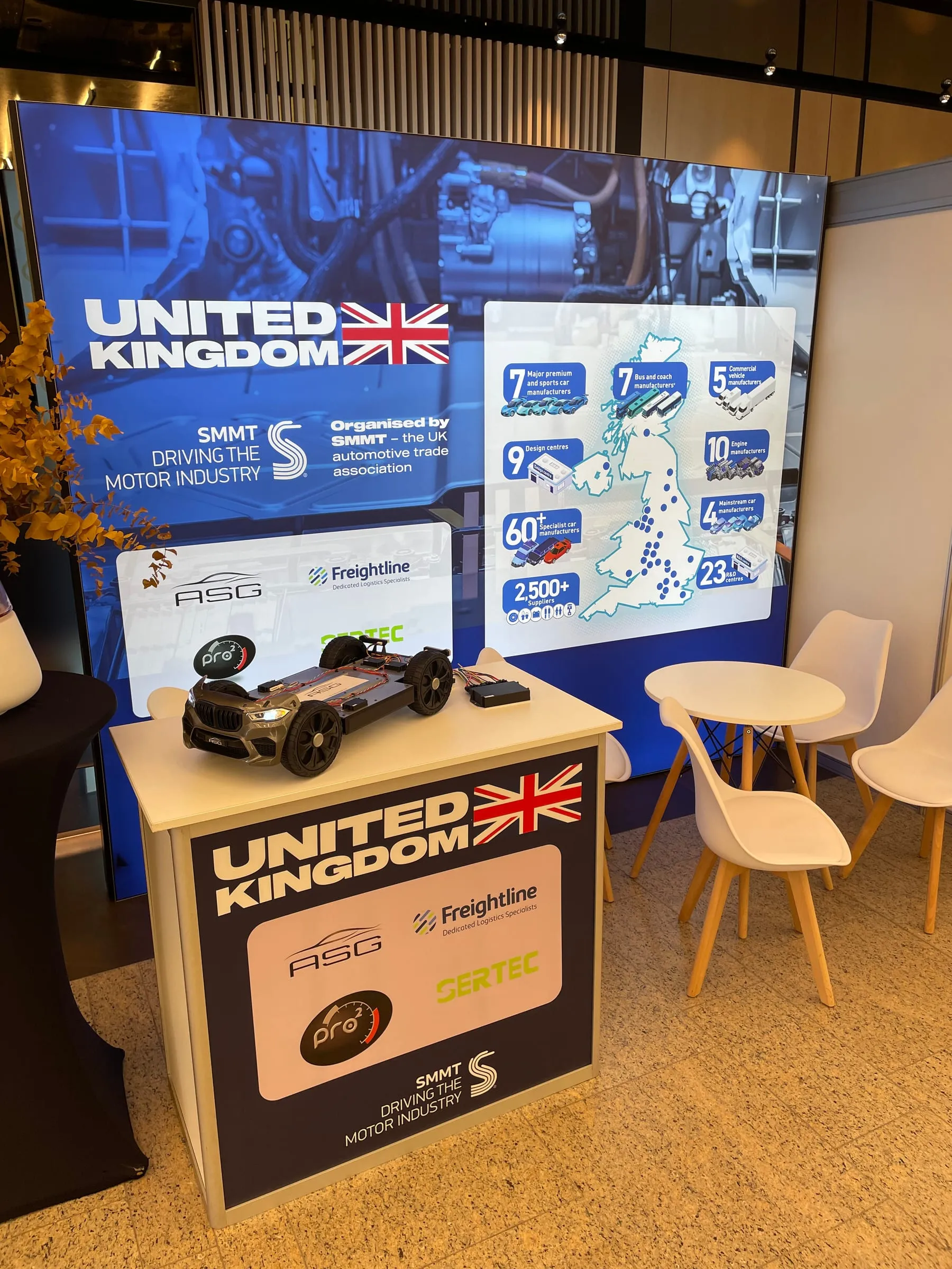 The SMMT United Kingdom pavilion in Olomouc, with the ASG logo and demo chassis on the stand.