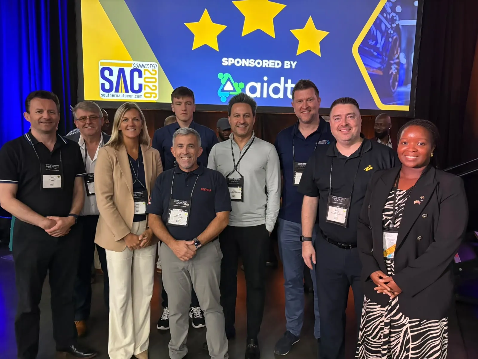 The UK delegation at the Southern Automotive Conference in Duluth, Georgia, standing in front of the SAC Connected 2026 screen.