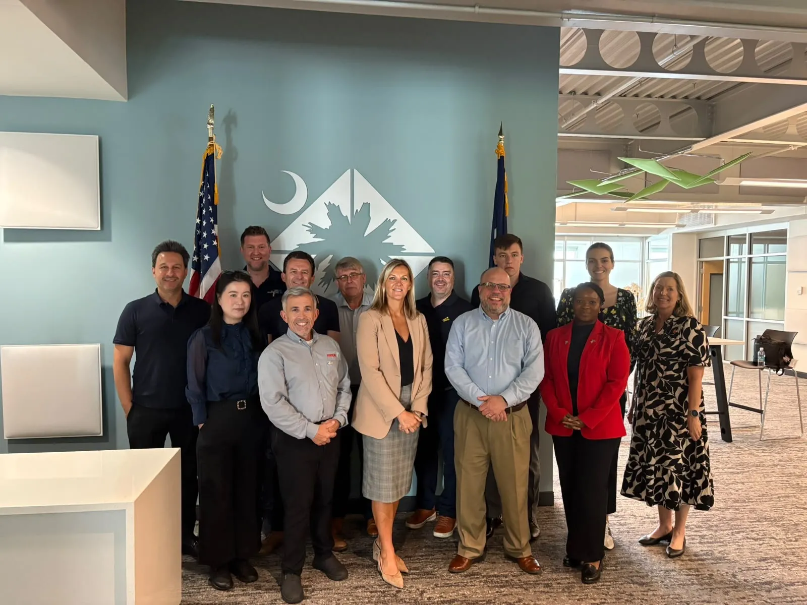 The delegation and hosts in front of the South Carolina crescent and palmetto emblem at the Upstate SC Alliance office.